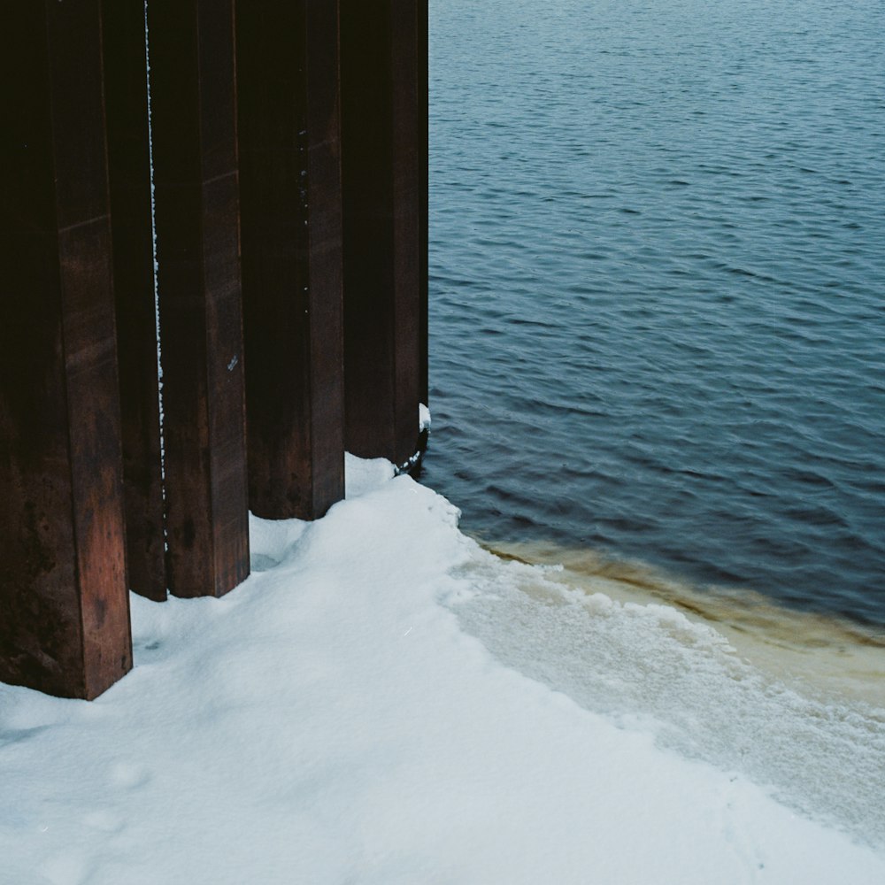 a view of a body of water with snow on the ground