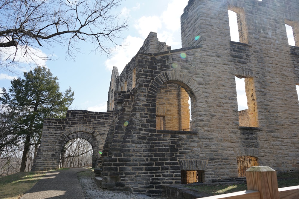 a stone building with a wooden fence in front of it