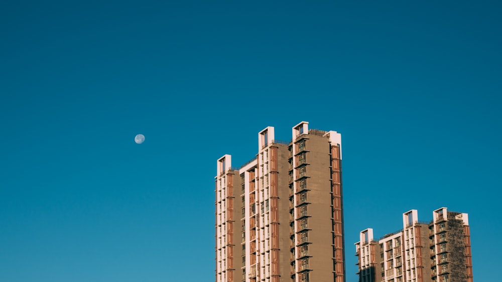 a very tall building with a half moon in the sky