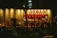A happy restaurant owner standing proudly in front of their bustling eatery.