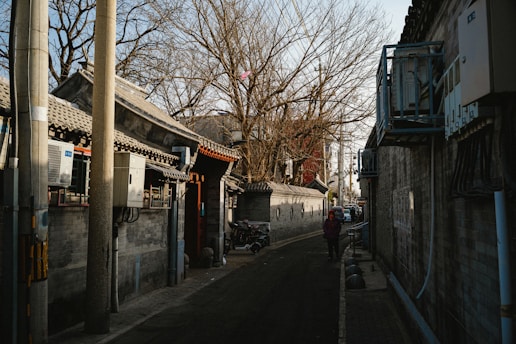 a person walking down a street next to a building