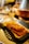 Close-up of a man holding a paper tray filled with golden fried meat pieces
