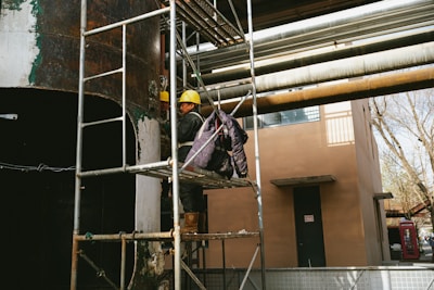 a man standing on a scaffold next to a building