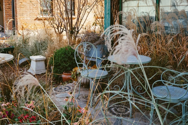 a couple of chairs and a table in a garden