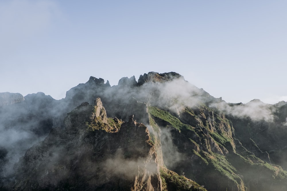 a very tall mountain with some clouds in the air