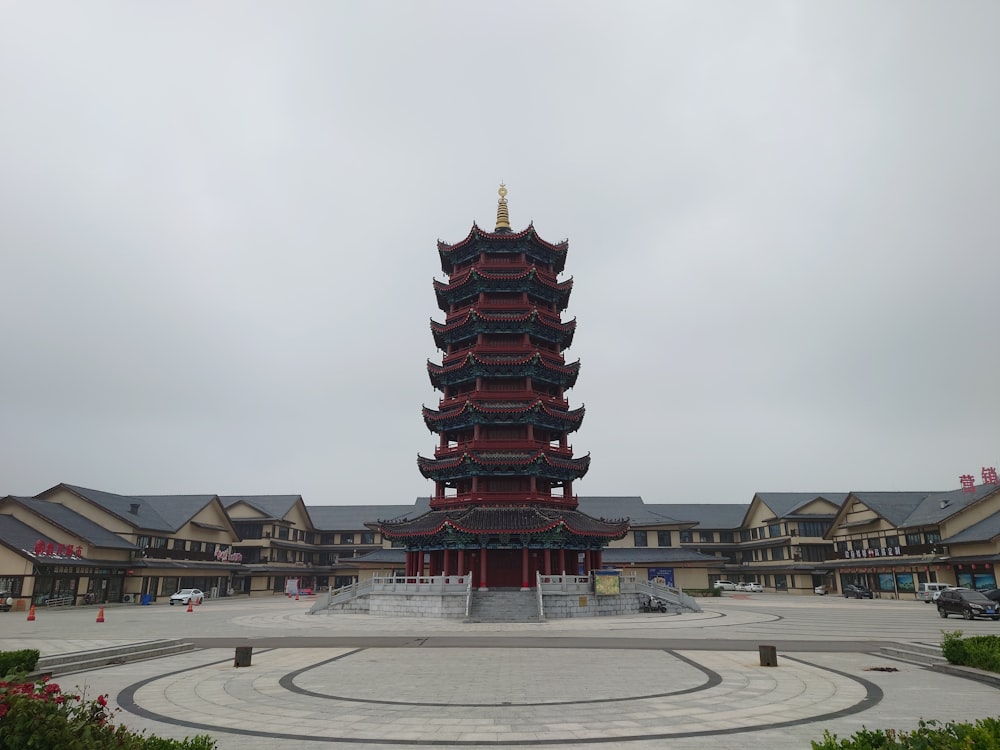 a tall red tower sitting in the middle of a courtyard