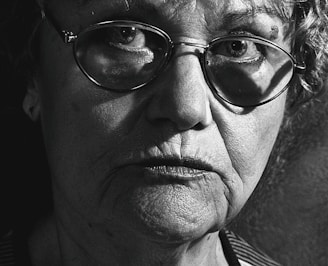 A close-up black and white portrait showing detailed emotions on an elderly person's face