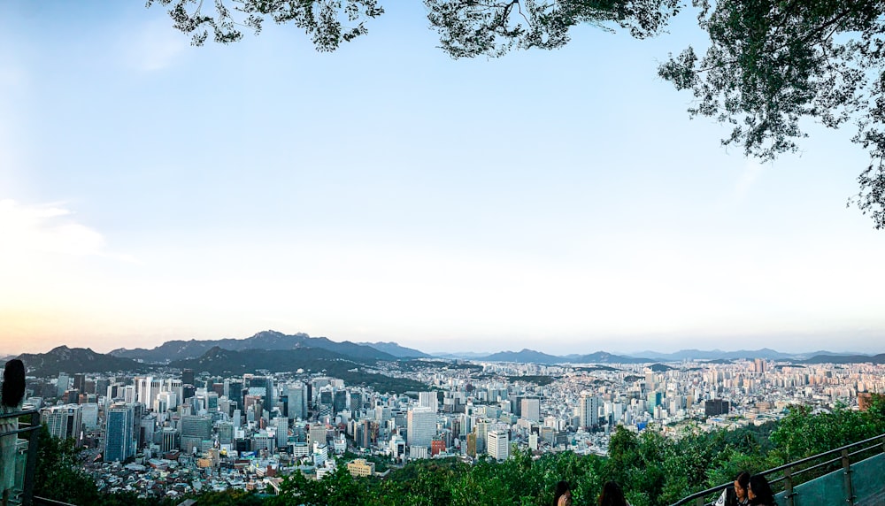 um grupo de pessoas sentadas em um banco com vista para uma cidade