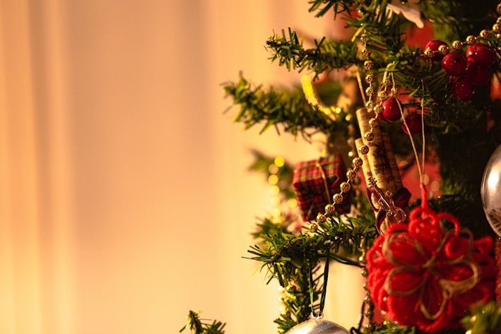 A cozy Christmas tree decorated with colorful handmade ornaments.