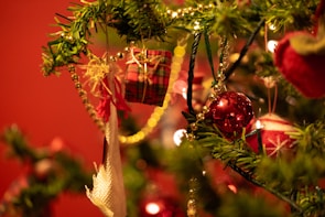 Close-up of unique Christmas ornaments hanging on a festive tree branch.