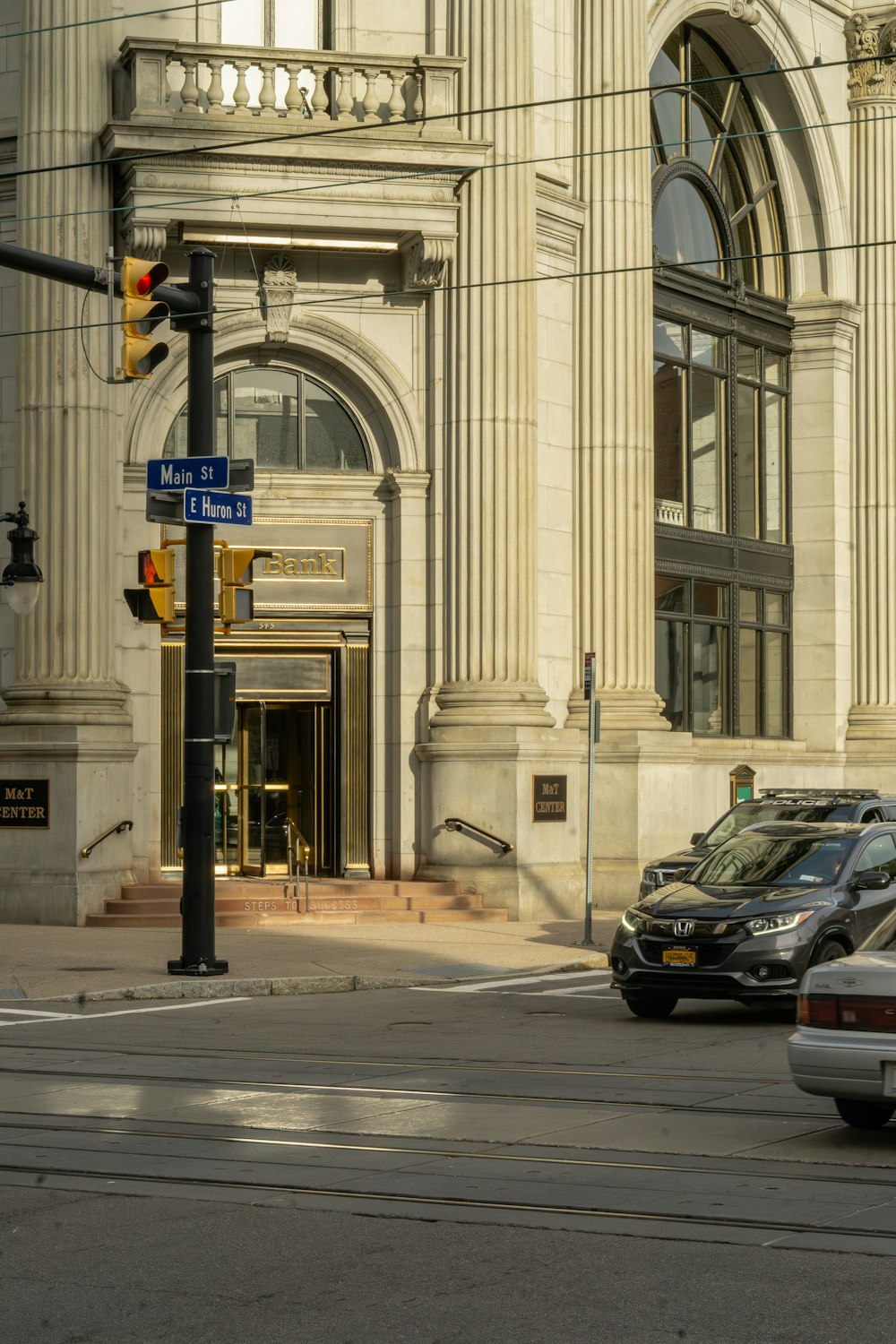 two cars are stopped at an intersection in front of a building