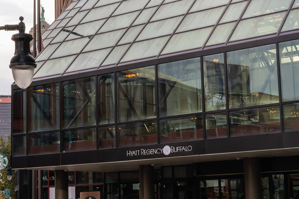 a large glass building with a clock on it's side