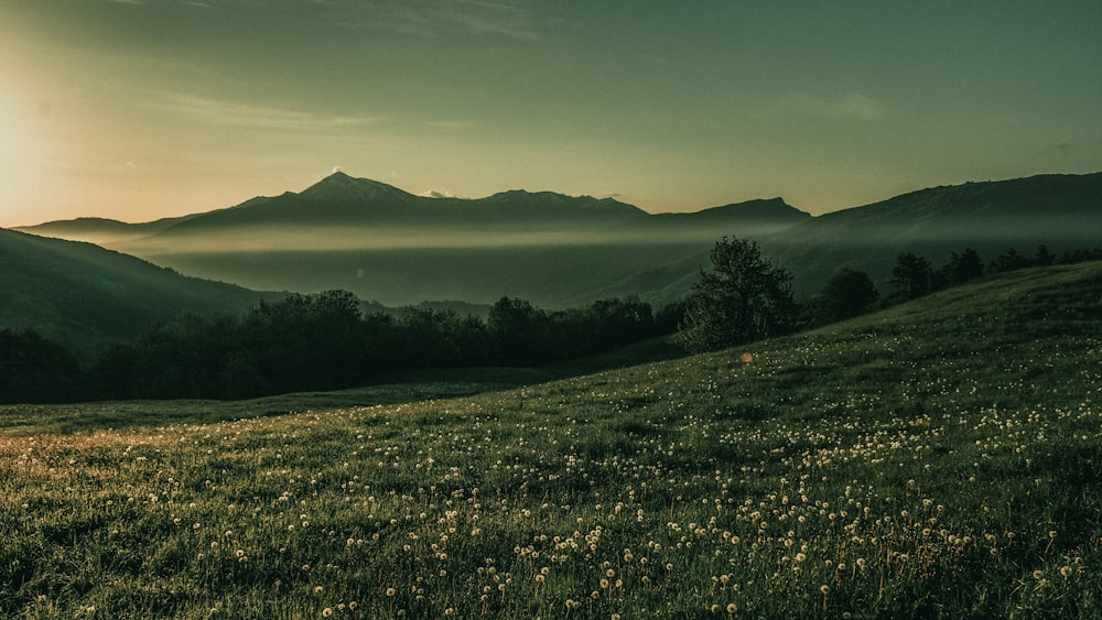 the sun is shining over the mountains in the distance