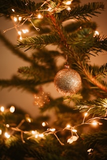 A close-up of sparkling Christmas lights on a beautifully decorated tree.
