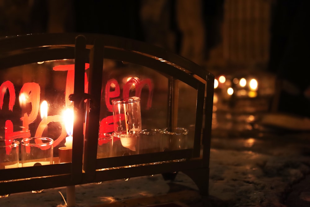 a lit candle is sitting in front of a window