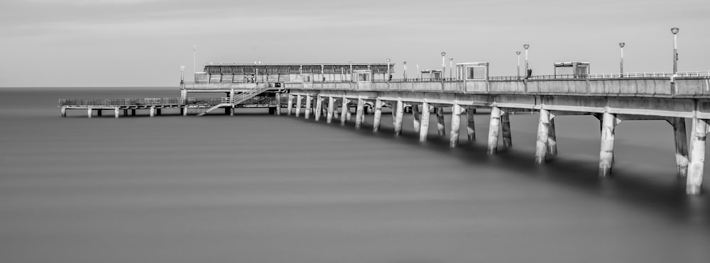 a black and white photo of a long pier