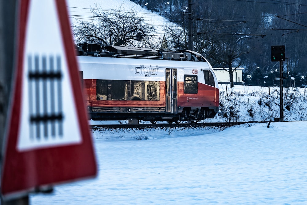 a red and white train traveling down train tracks