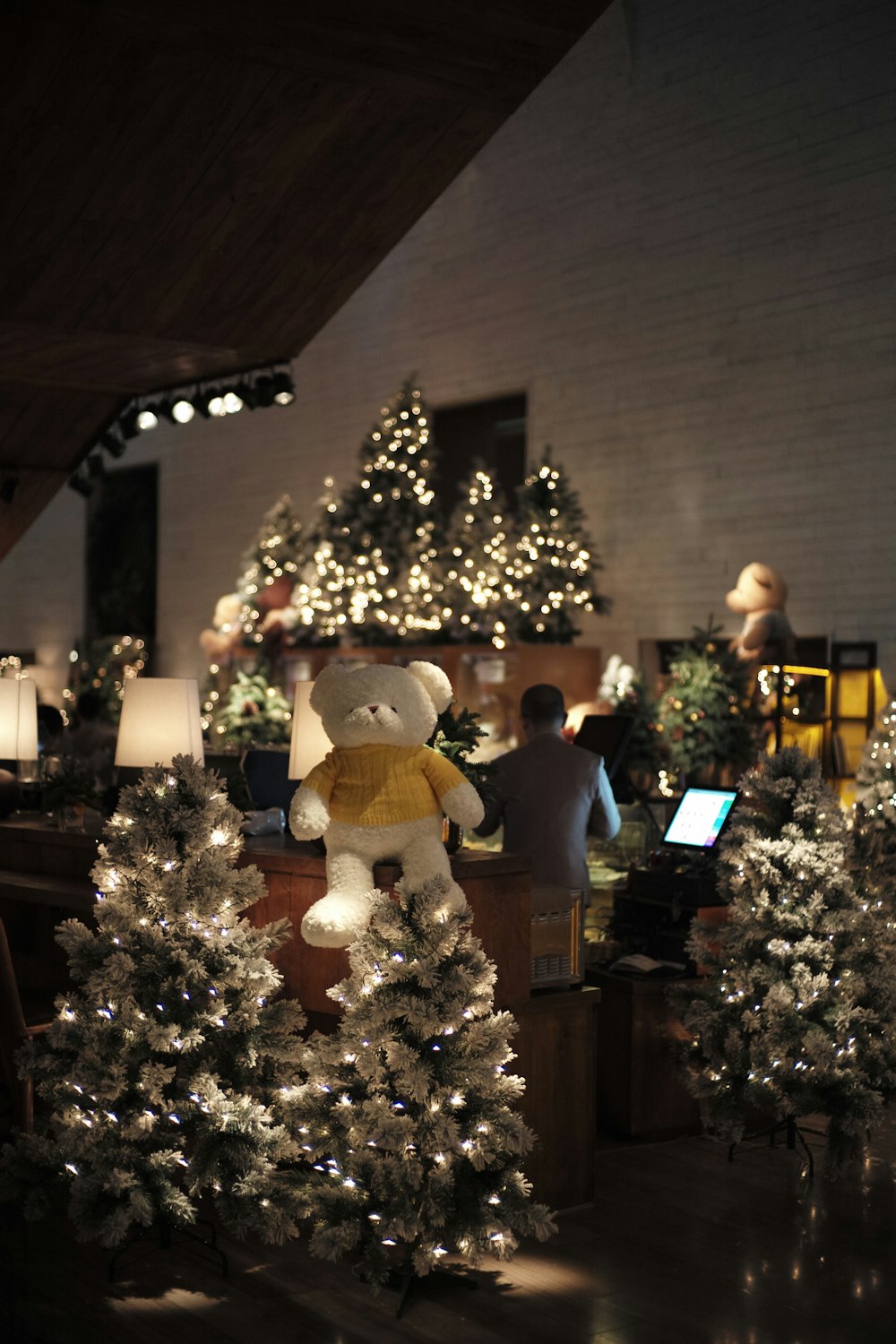 a teddy bear sitting on top of a christmas tree