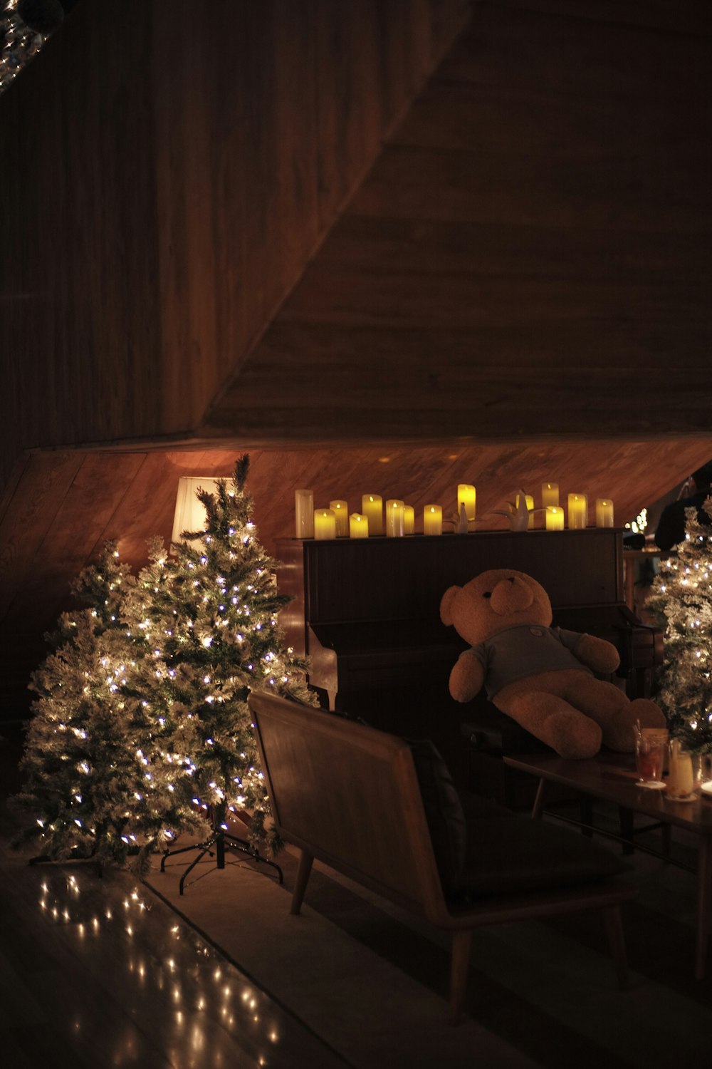 a teddy bear sitting in a chair next to a christmas tree