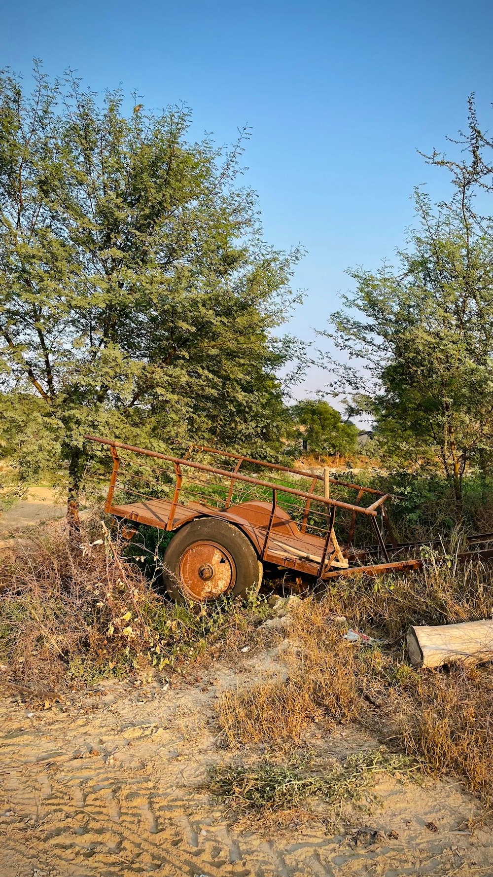 an old rusted truck sitting in the middle of a field