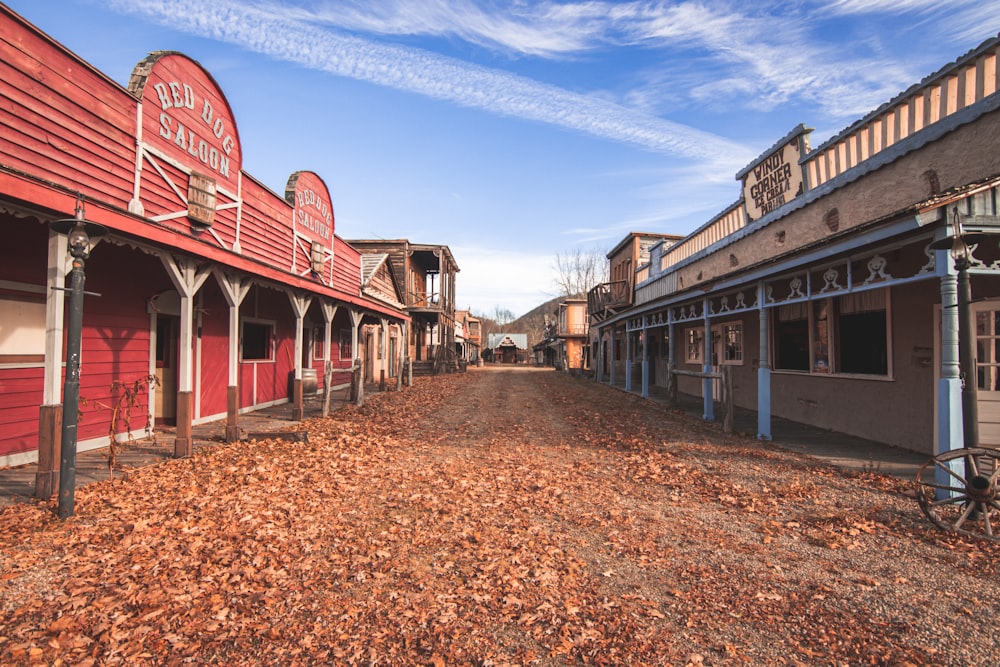 a dirt road in front of a red building