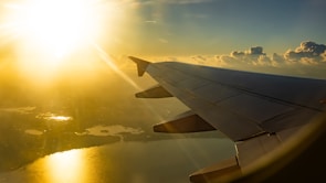 Air cargo plane taking off with golden sunlight reflecting on its wings.