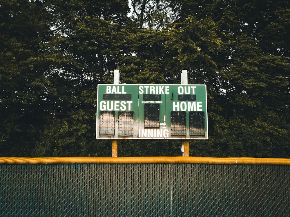 a street sign on a fence with trees in the background