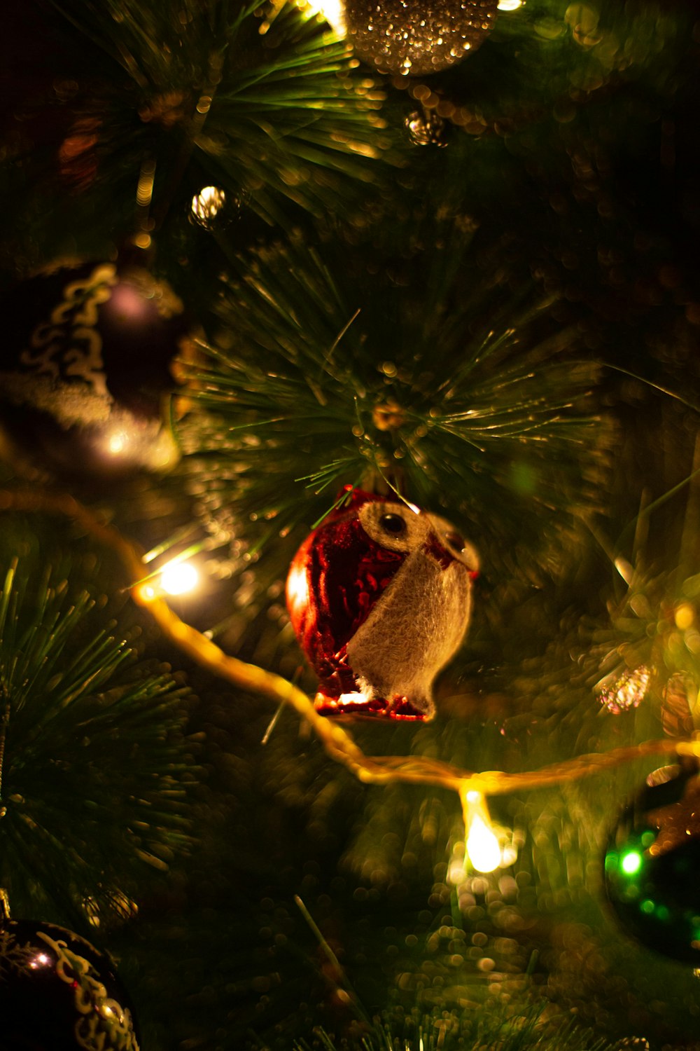 an owl ornament hanging from a christmas tree