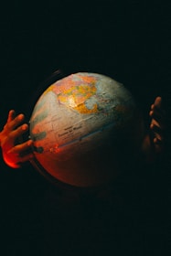 A globe surrounded by hands symbolizing global opportunities.