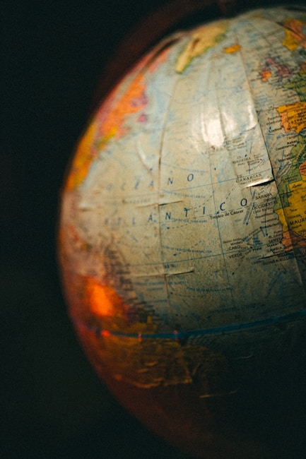 A close-up view of a globe with visible text in Spanish, showing parts of the Atlantic Ocean. The image is warmly lit, creating a nostalgic atmosphere.
