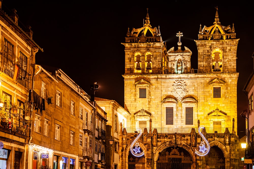 a city street at night with a clock tower in the background