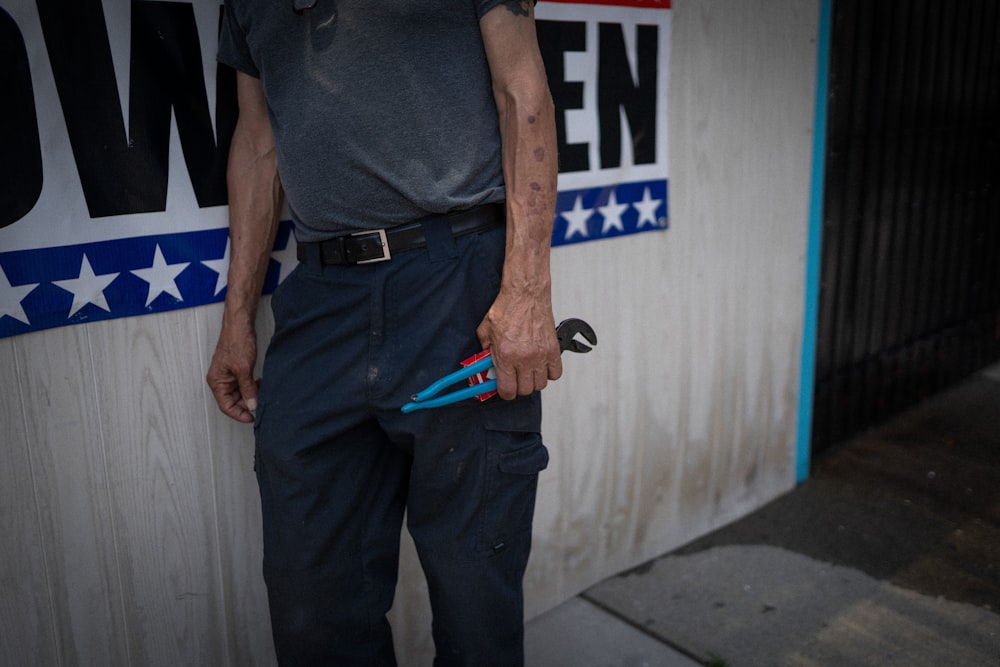 a man standing in front of a building holding a pair of scissors