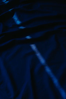 Navy blue deadstock fabric with subtle weave patterns illuminated by natural light.