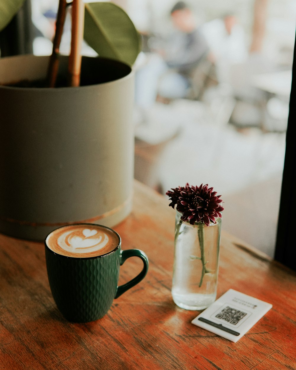 a cup of coffee sitting on top of a wooden table