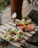 A colorful spread of plant-based dishes beautifully arranged on a rustic wooden table outdoors.