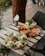 A colorful spread of plant-based dishes beautifully arranged on a rustic wooden table outdoors.