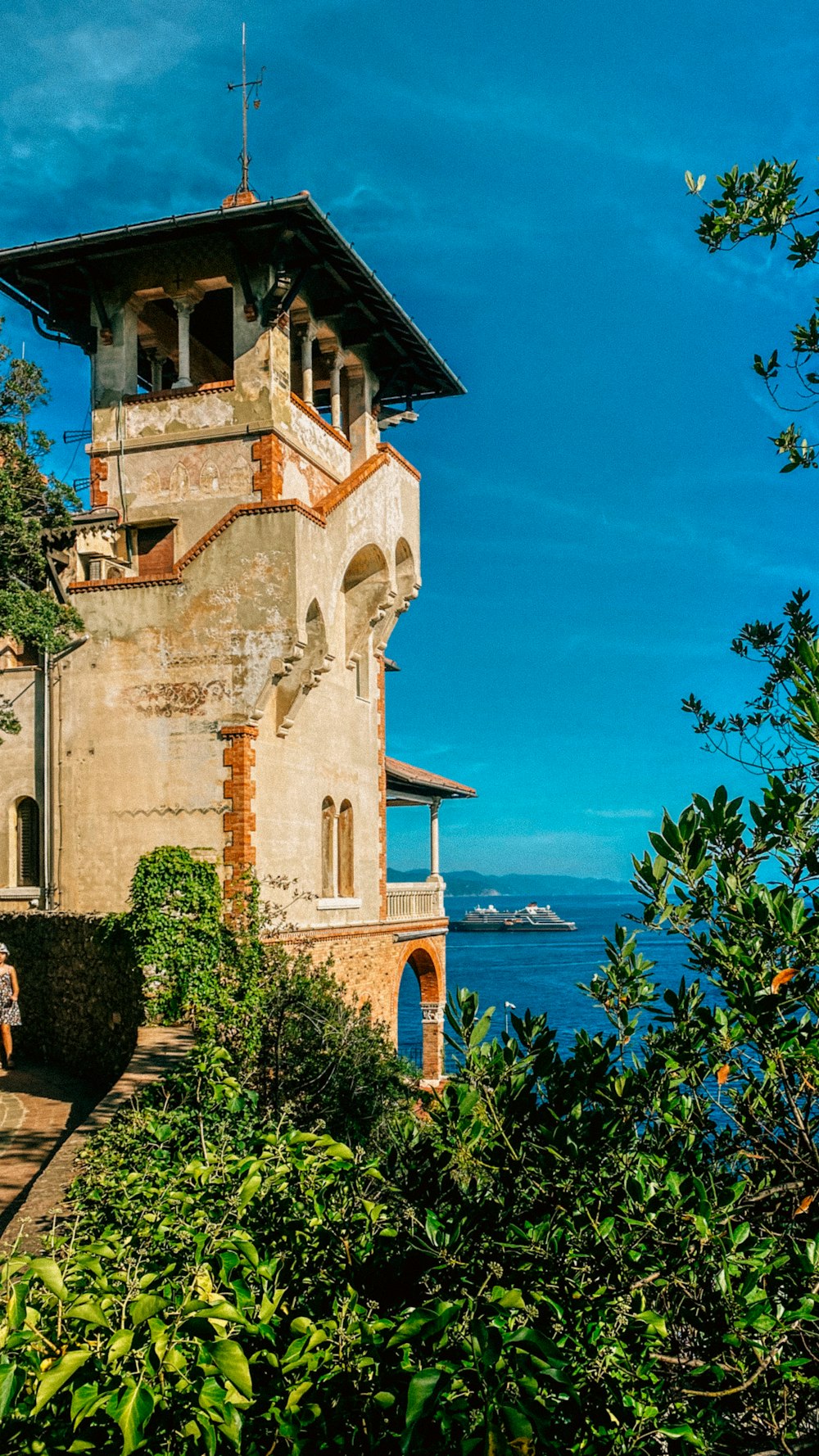 a tall tower sitting on top of a lush green hillside