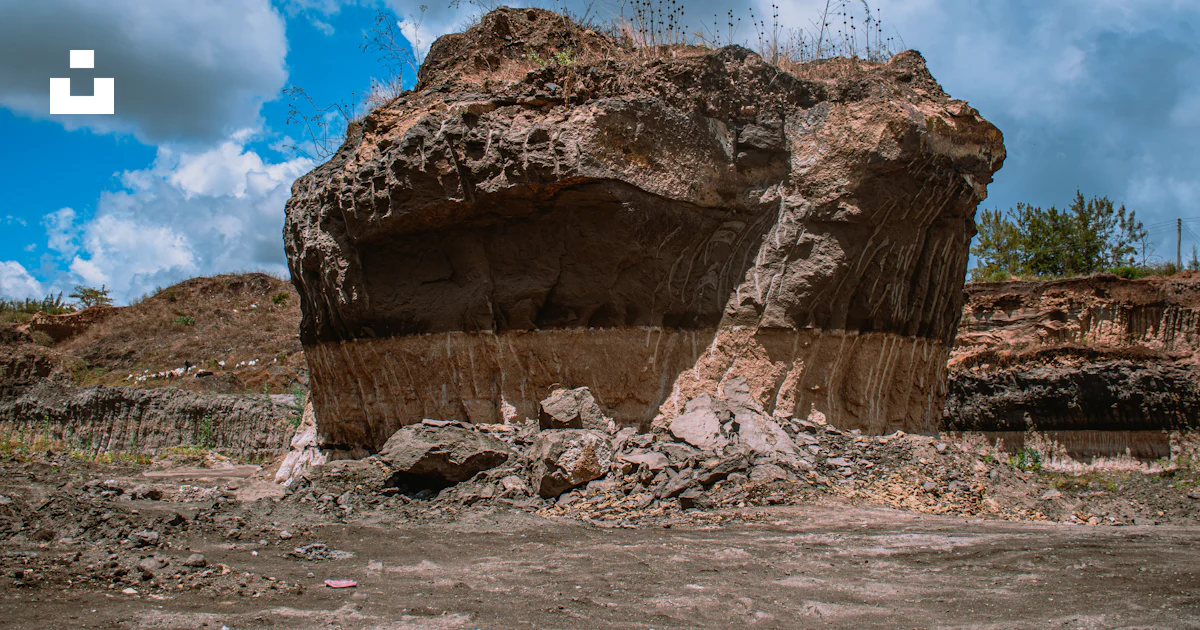 Gran Roca Una gran roca sentada en la parte superior de un campo de tierra foto ...
