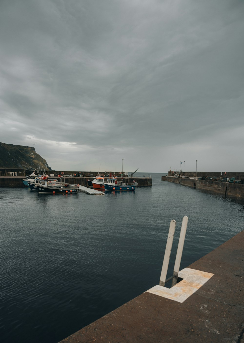 a harbor filled with lots of boats under a cloudy sky