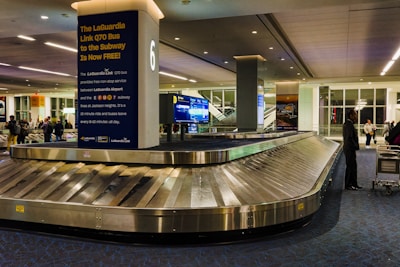 a baggage claim area at an airport with people walking around