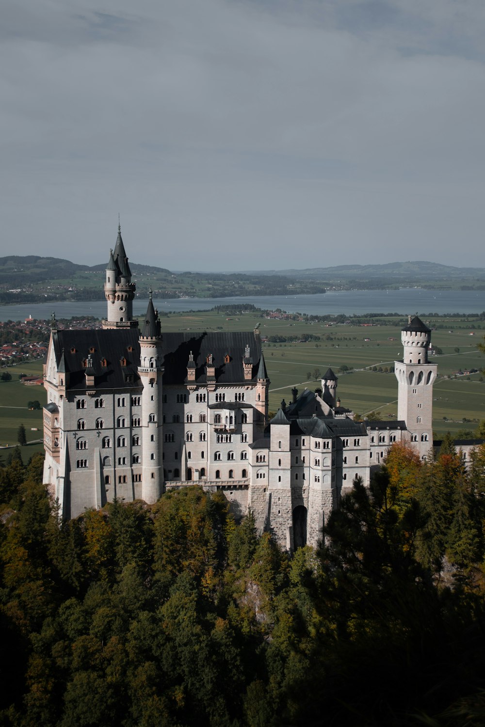 a large castle sitting on top of a lush green hillside