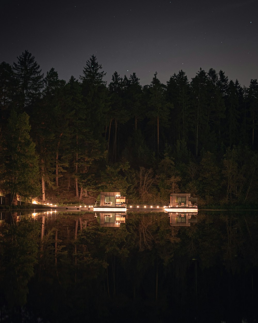 a night time scene of a cabin on a lake