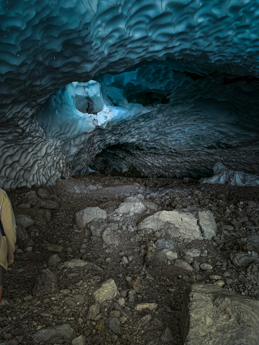 a man standing in a cave with a backpack