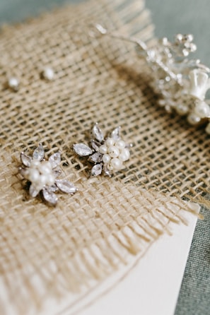 Elegant earrings with tiny crystals displayed on a vintage lace cloth.