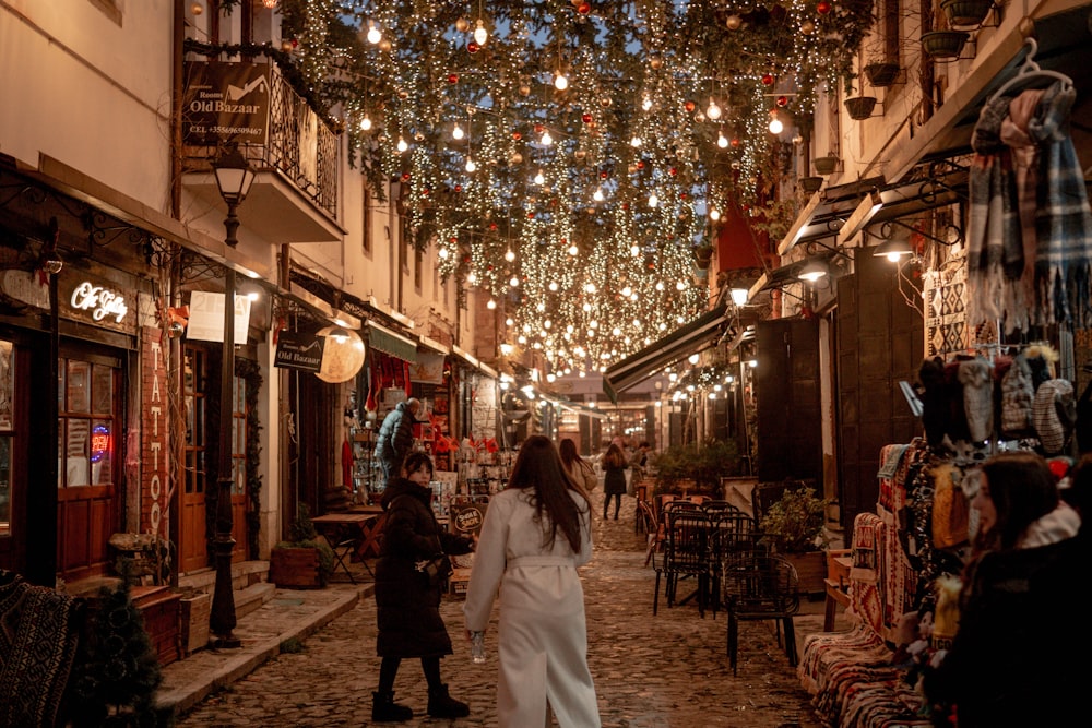 a woman in a white dress walking down a street