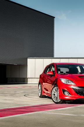 a red car parked in front of a building