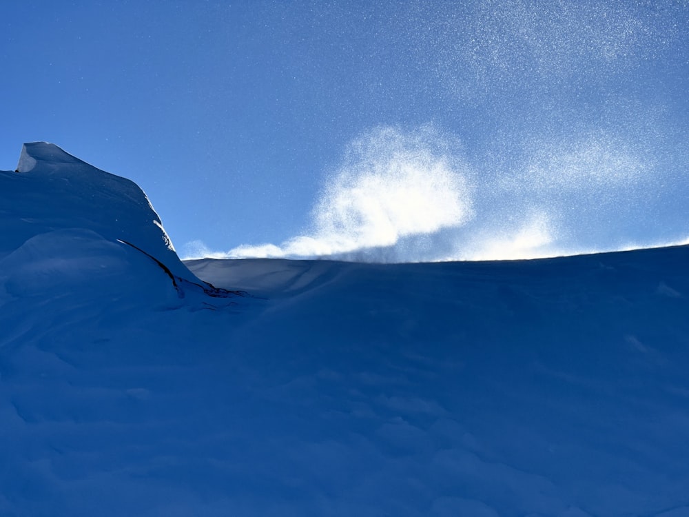 a person riding a snowboard down a snow covered slope