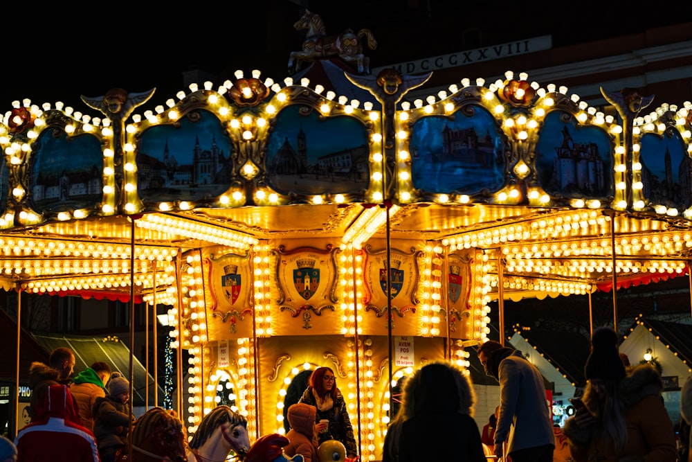 a merry go round at night with people standing around