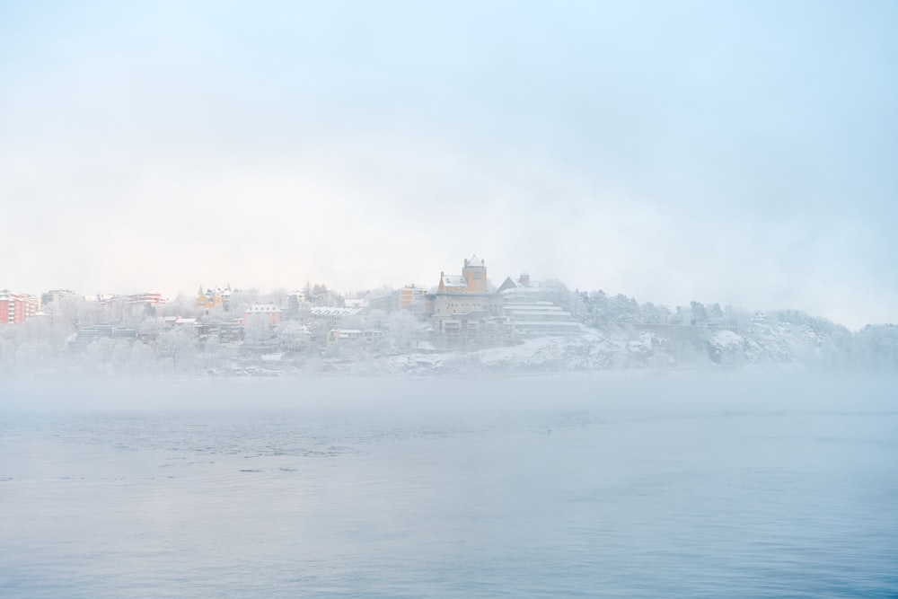 a foggy day over a city on a lake