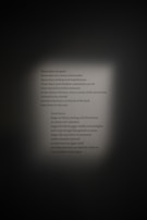 The image displays a poem in both English and Swedish, centered on a wall with a spotlight effect. The poem reflects on the nostalgia of days filled with wonder and the bravery of those unafraid of the dark.
